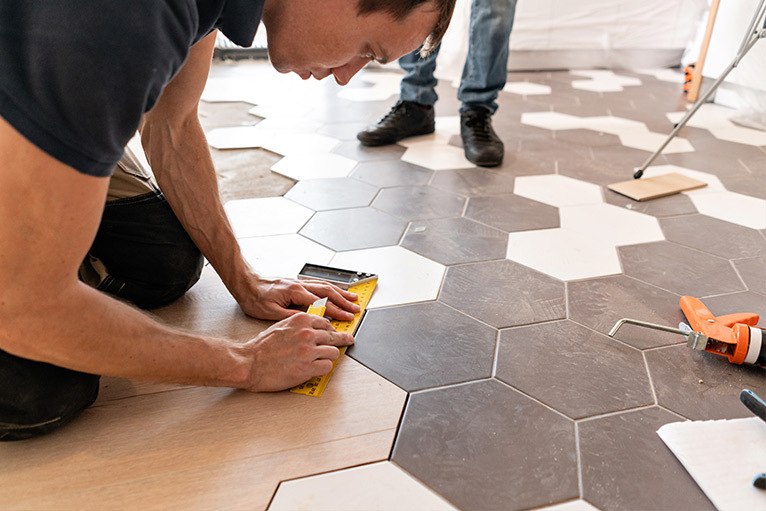Tiler fitting hexagonal floor tiles