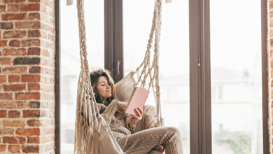 Girl reading in a hammock chair suspended from the ceiling
