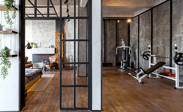 House extension with concrete walls and spotlights, split into a home gym and a bedroom