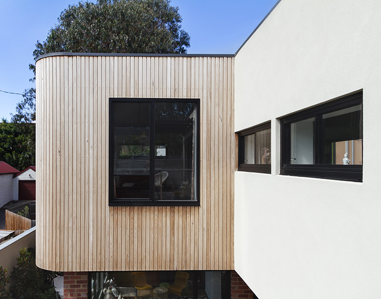 Two storey house extension with wood panel facade