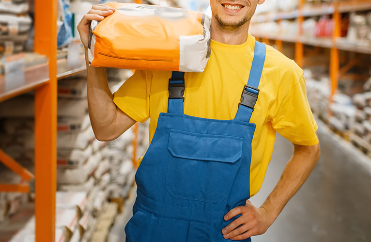 Smiling tradesperson carrying materials on their shoulder