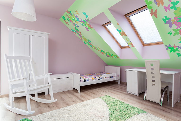 Pink kids' loft bedroom with a green feature wall that has multicoloured butterflies on it