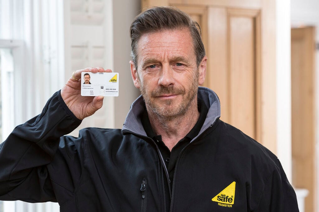 Gas and heating engineer holding his Gas Safe ID card