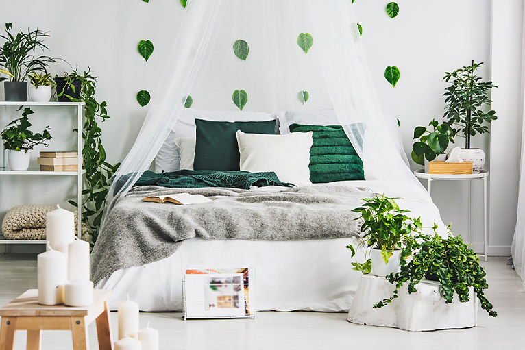 Bright and airy bedroom with plants and candles