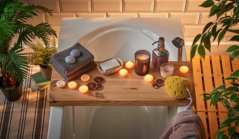 over-bath caddy holding candles, flannels and soap