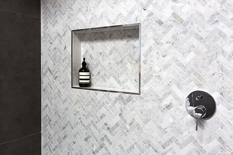 Grey herringbone tiles inside a shower