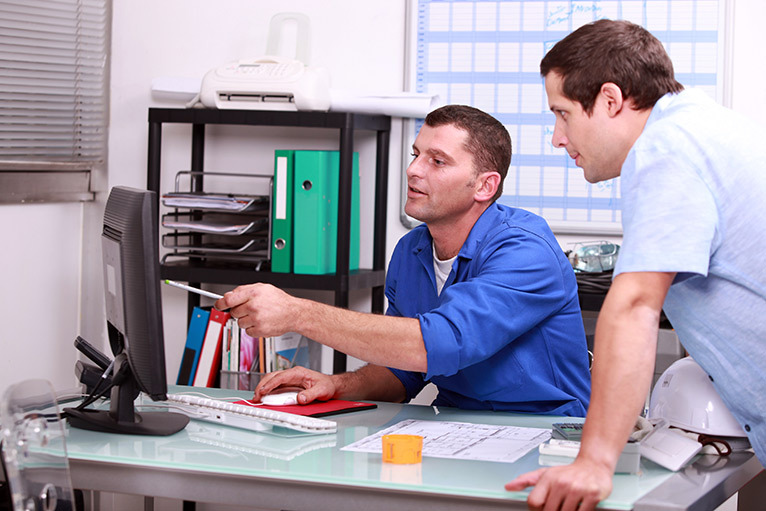 Tradespeople looking at a computer