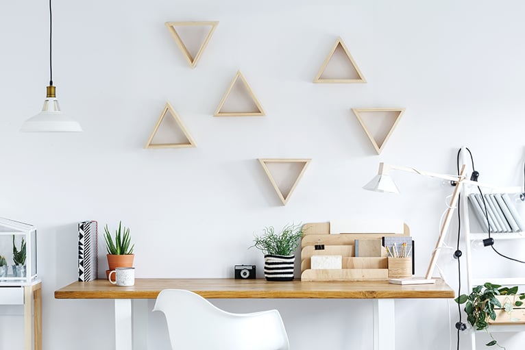 Desk in front of a wall with a wooden geometric cut out design
