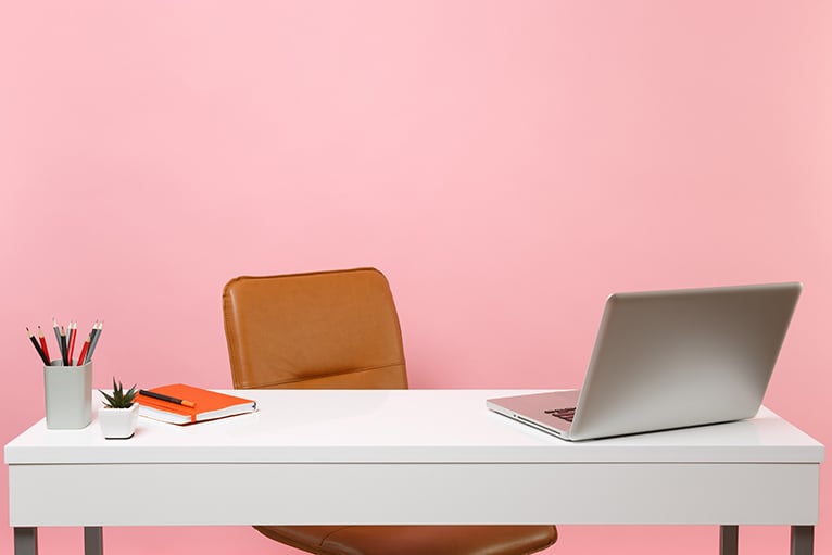 Desk in front of pink wall in home office