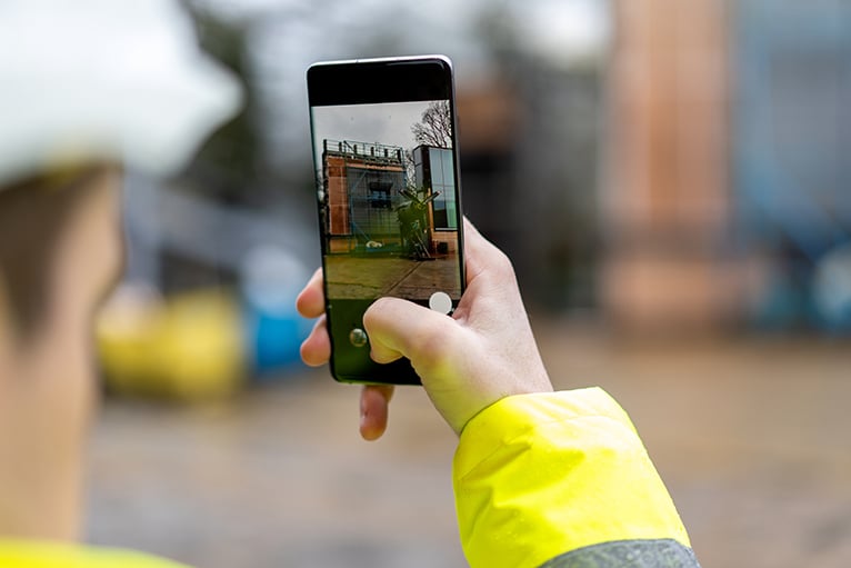 Tradesperson taking a picture on site using a smartphone