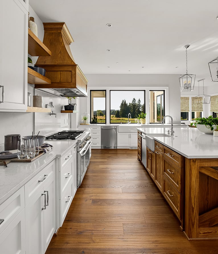 Kitchen with wooden flooring, two farmhouse sinks and white cabinets