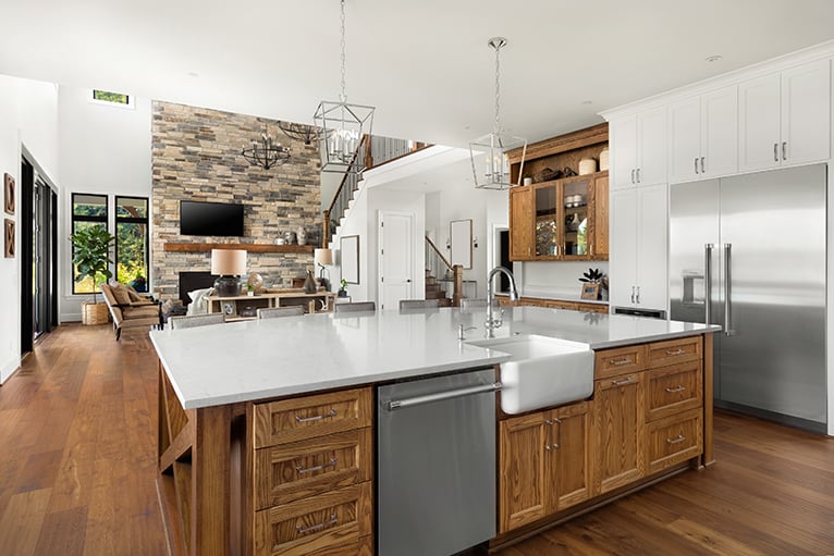 Kitchen island with farmhouse sink, hardwood floors and stainless steel appliances
