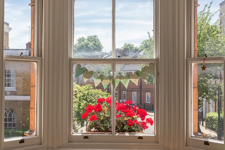 Bright red flowers outside a bay window
