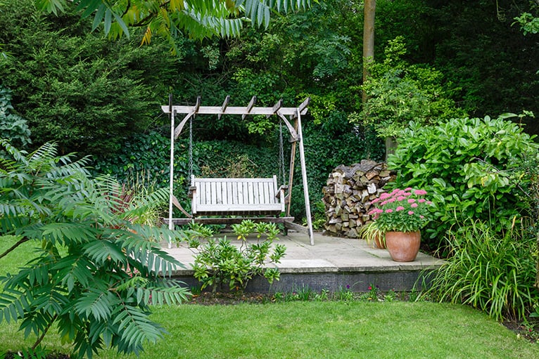 Garden swing on raised platform in garden