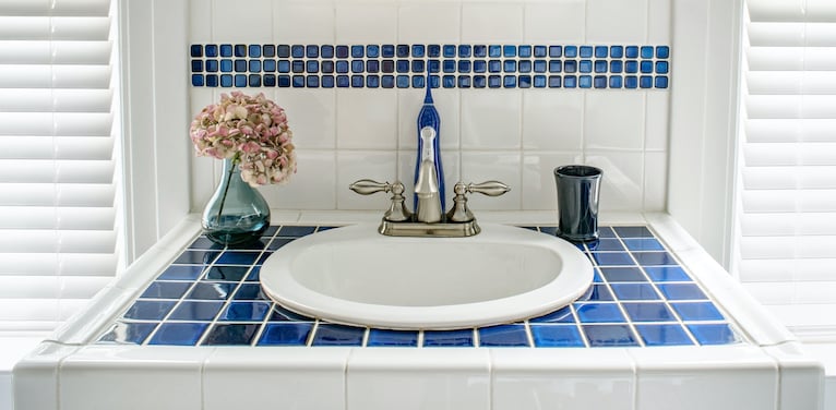 Sink surrounded by blue and white tiles