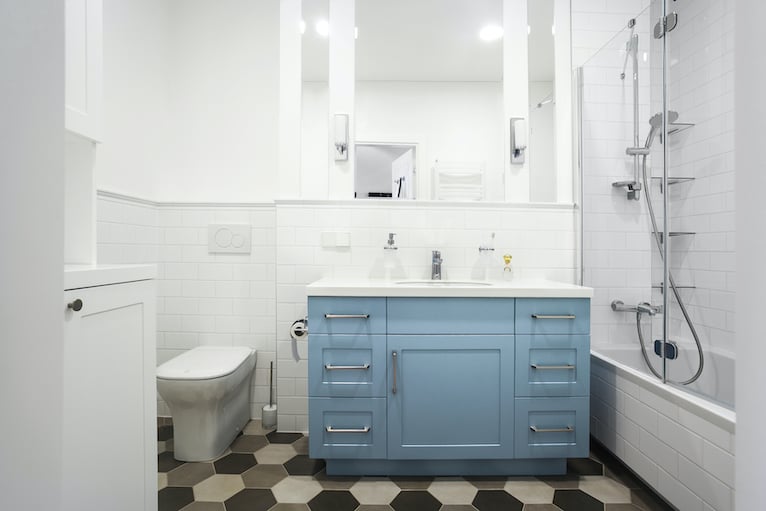 White bathroom with pastel blue under sink cabinet