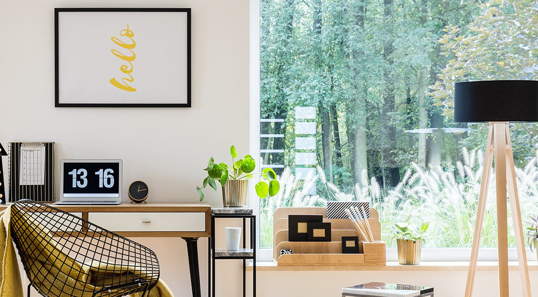 Home office with white walls and big window.