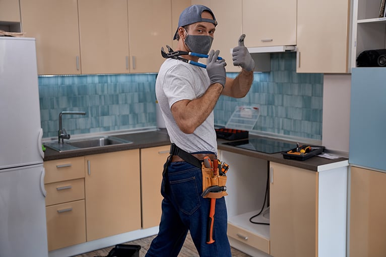 Tradespeople: Kitchen fitter wearing mask and giving a thumbs up to the camera