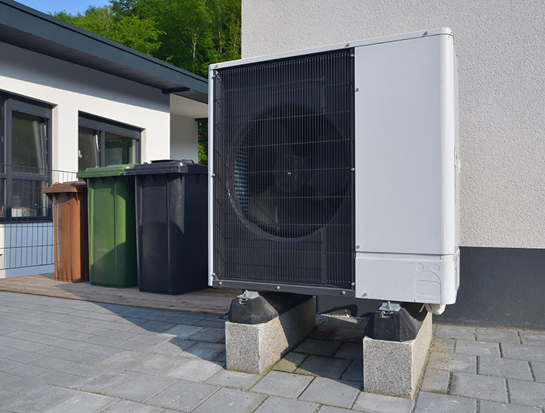 Air source heat pump in front of apartment building