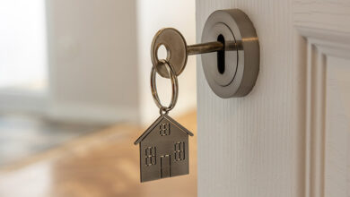 Key with house-shaped keyring in the door to a new home