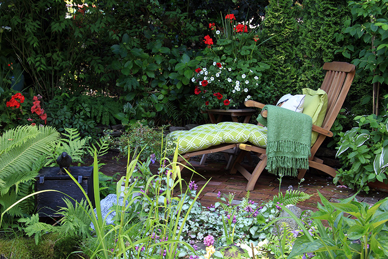 Lounge chair in garden with lots of plants