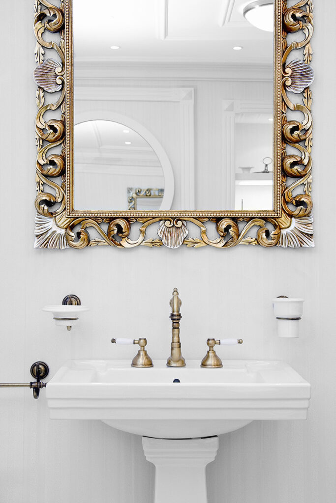 Carved gilded mirror above bathroom sink