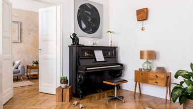 Black upright piano in corner of room