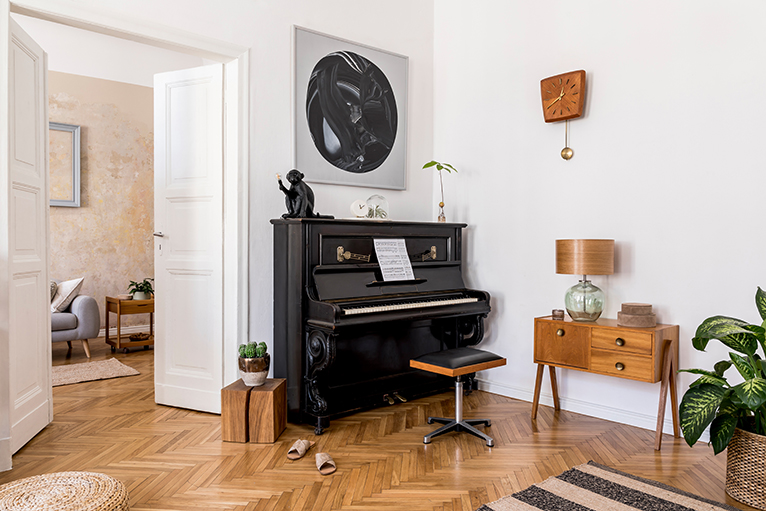 Black upright piano in corner of room