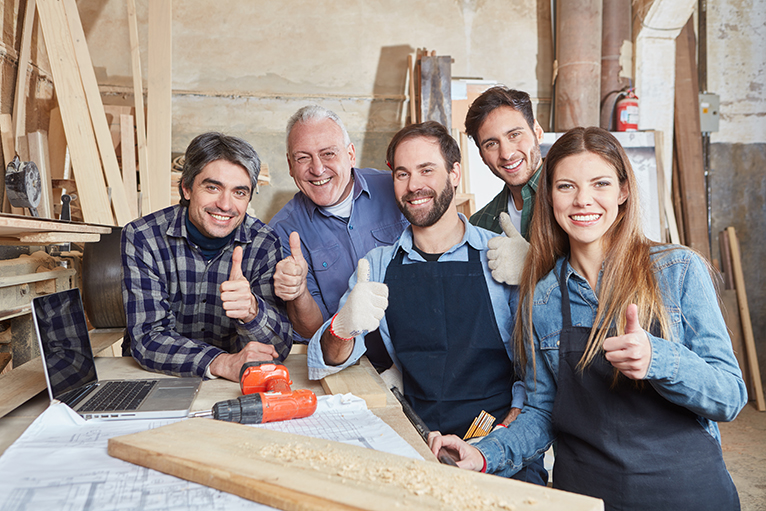 Group of carpenters smiling and putting thumbs up