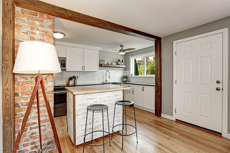 Kitchen with small island and exposed brick interior