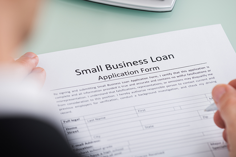 small business banking: Person filling in loan application form