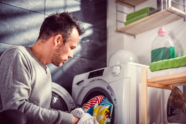 Water efficient home: Person loading laundry in washing machine