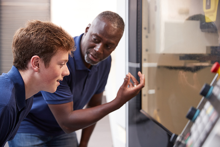 Engineer teaching apprentice on a trades apprenticeship