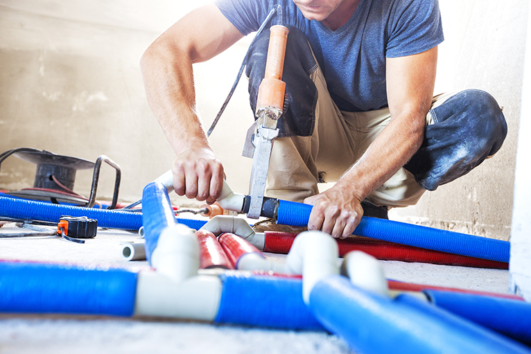 Plumber working on pipes