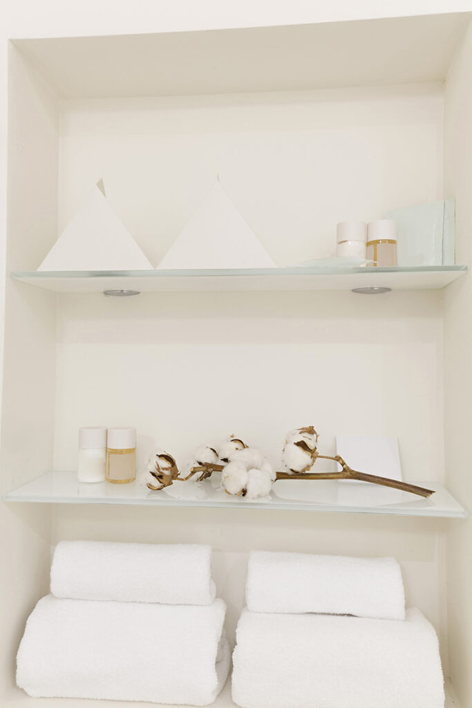 Glass shelves with towels and toiletries