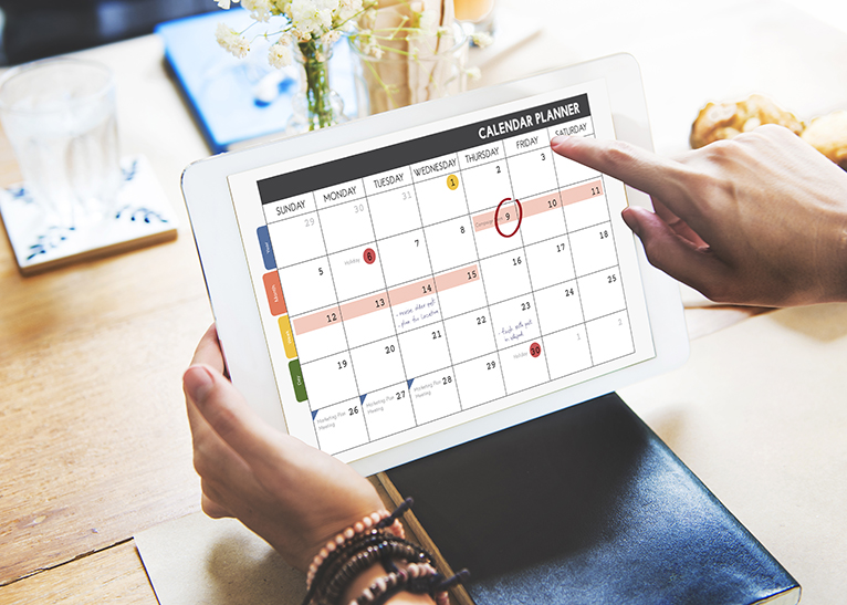 Planning social media marketing: Person using calendar on tablet