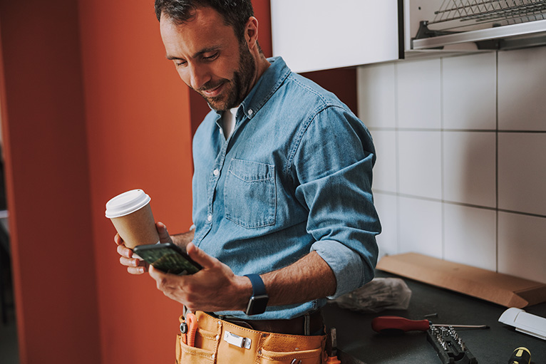 Tradesman smiling at mobile phone