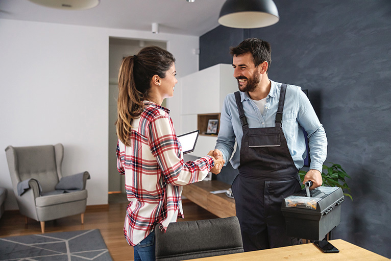 Happy customer shaking hands with handyman and giving a positive online review