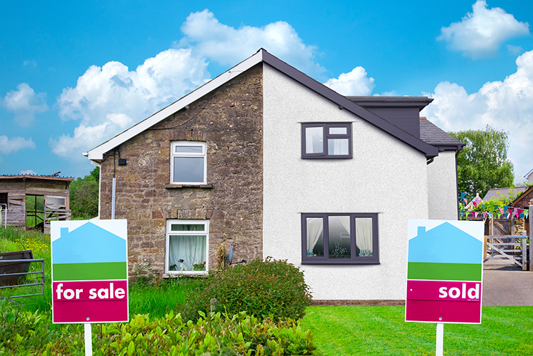 For Sale and Sold signs outside semi detached houses