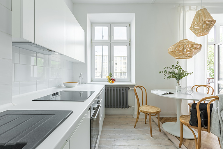 White kitchen with round table and wooden chairs