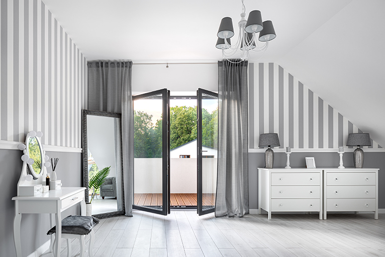 Grey bedroom with white furniture and large balcony doors