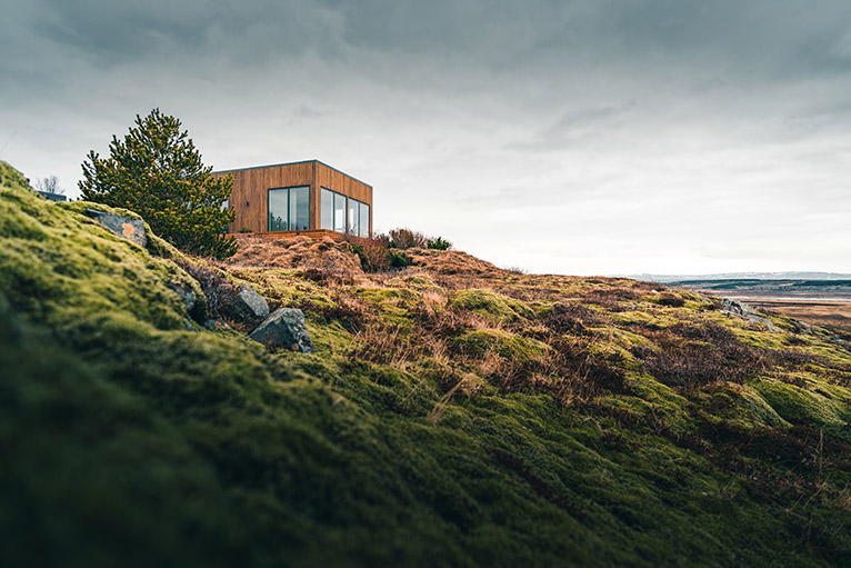 Tiny home on a grassy hill in an isolated location