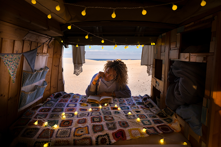 Person reading next to hanging pockets in camper van