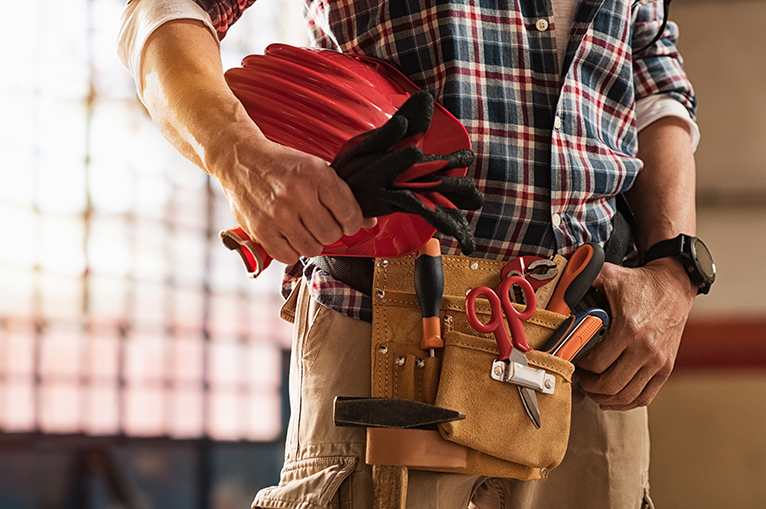 Tradesperson carrying tools in tool belt
