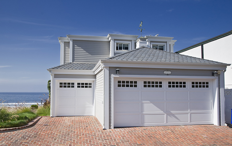 Grey and white beach house with double garage