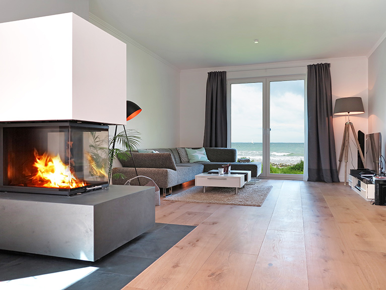 Modern interior with fireplace, wooden flooring and sea view