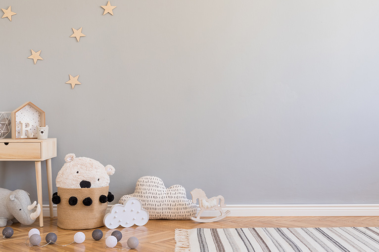 Scandinavian style nursery with light grey wall, wooden stars, natural toys and wooden furniture