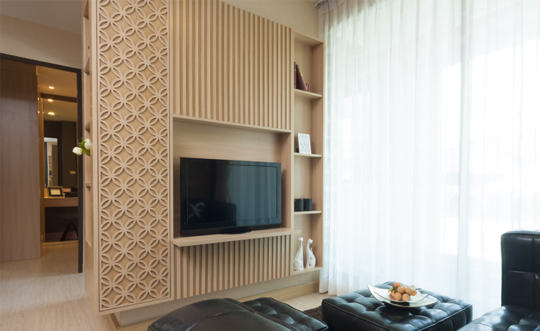 Striking wooden slats make up a feature wall of a TV unit in the corner of a lounge. 
