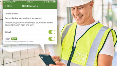 Tradesman wearing hard hat and yellow vest looking at his mobile phone. The screen shows how to enable push notifications.