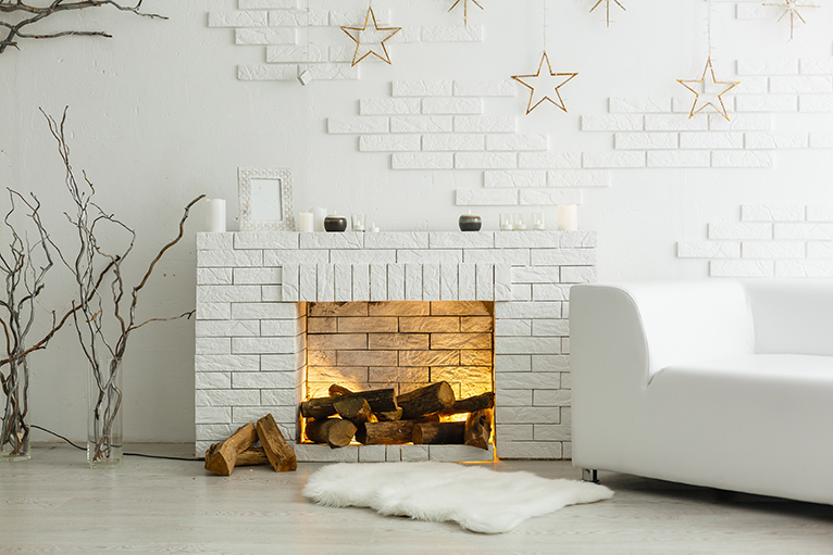 Faux fireplace made to look real with scattered wooden logs and a light to act like a yellow flame.